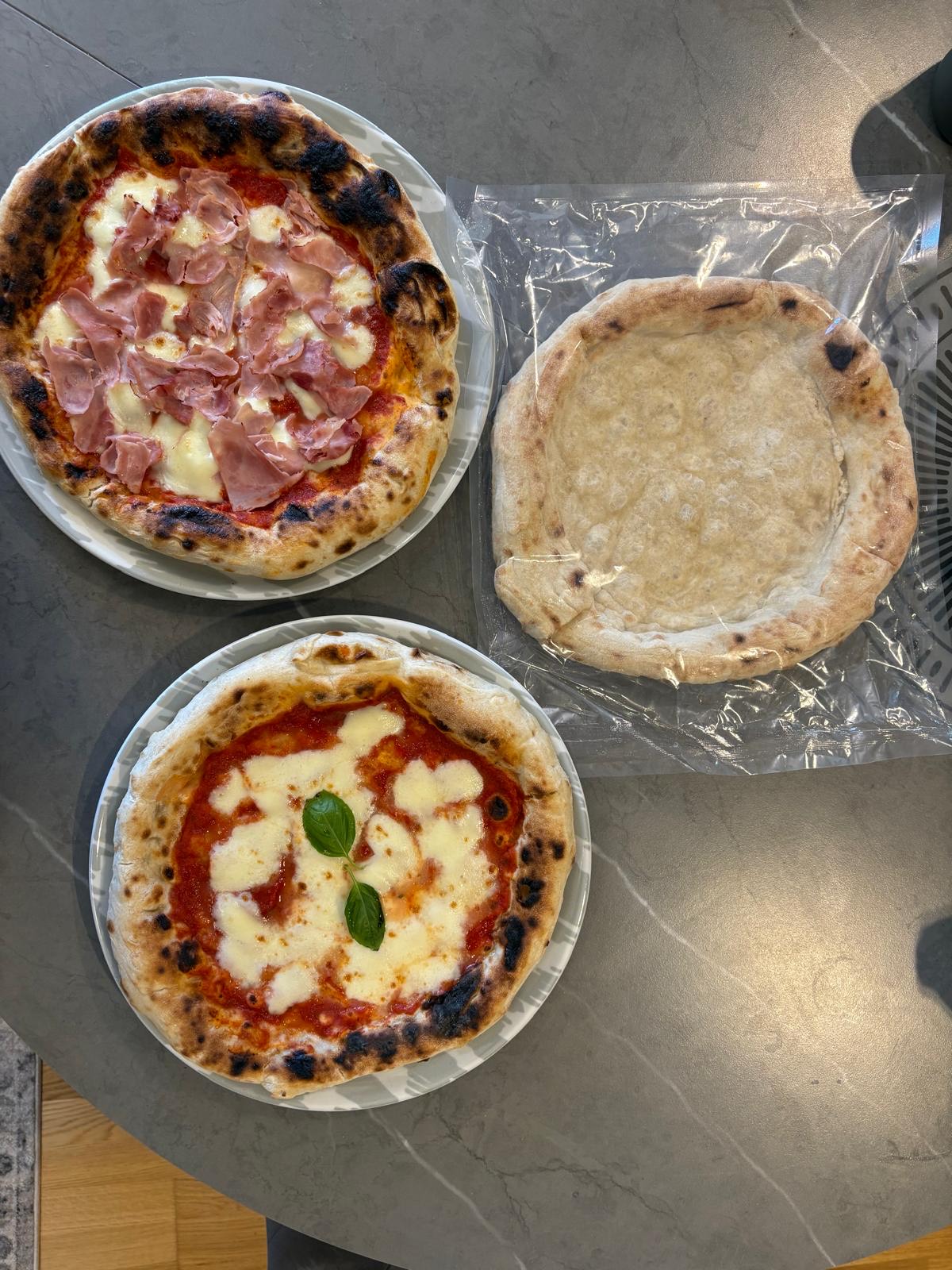 Predpečený korpus vo vákuovom balení a dve hotové pizze